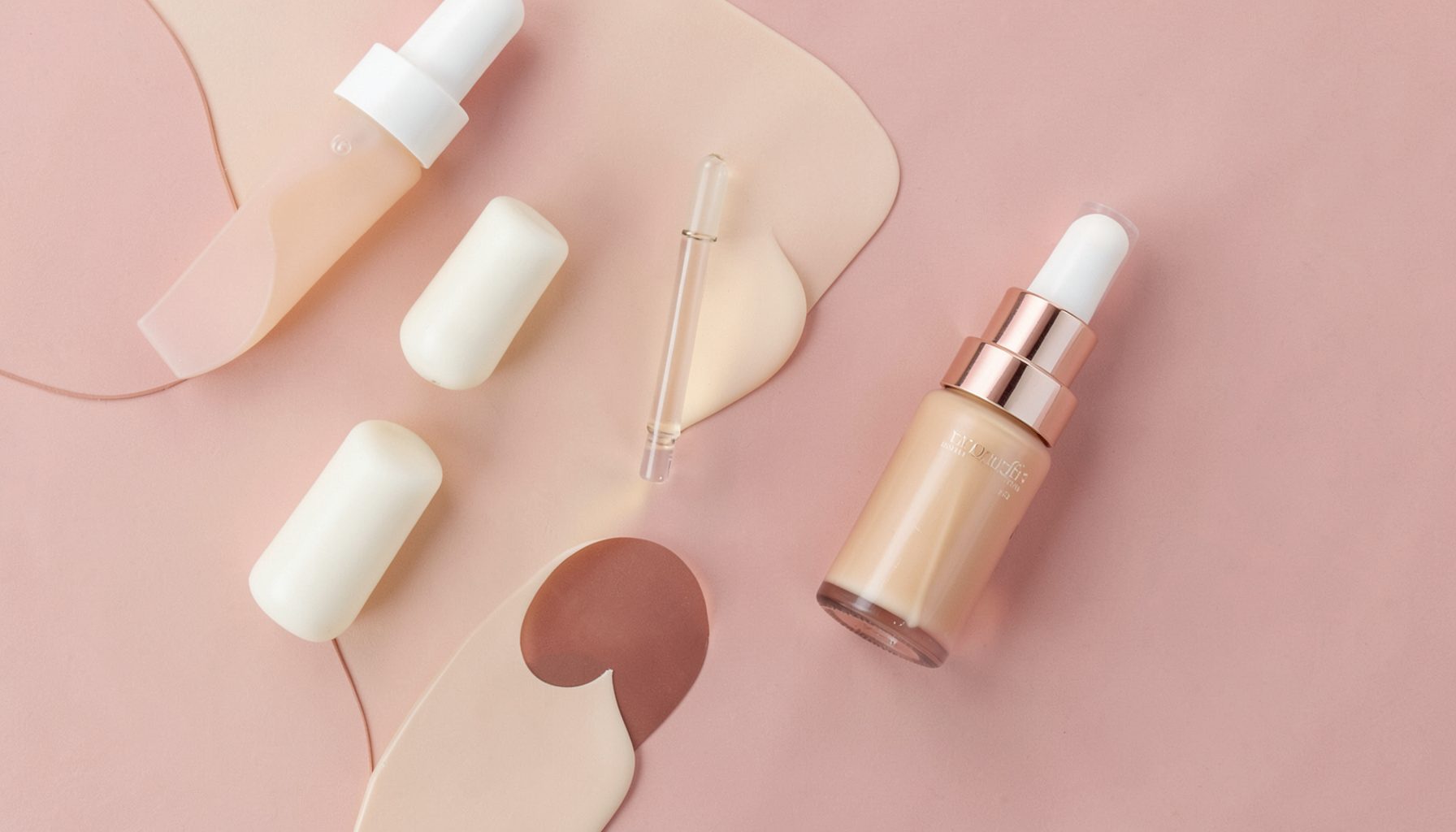 Soft flat-lay of skincare bottles and a dropper serum in warm cream and dusty pink tones, calm and clean mood